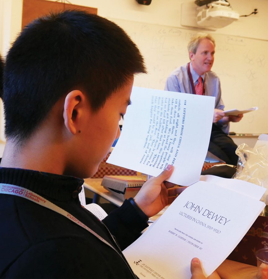 DEWEY FUN. Bruce Li, a student at Ren Da Fu Zhong high school in Beijing, reads about Lab Schools founder John Dewey during a presentation Feb. 2 with Director Charlie Abelmann. RDFZ exchange students will be invited to attend a May 2019 conference commemorating Dewey’s 1919 China trip.