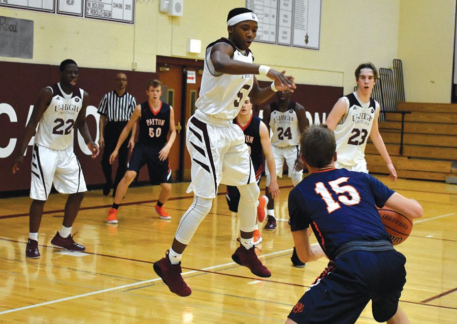 FLOAT LIKE A BUTTERFLY. Junior Johnny Brown leaps up as he attempts to block his opponent in a game against Walter Payton College Prep Jan. 30. The varsity boys team won 80-66.