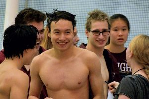 ALL SMILES. Teammates and friends smile with Horace Shew, center, to congratulate him after a race, during the meet against St. Ignatius College Prep Jan. 30 at the Ratner Athletic Center.  