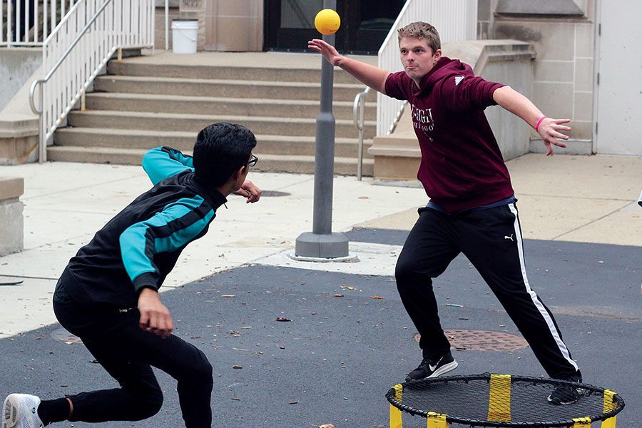 SPIKE IT. Winding up to hit the ball, Zach Leslie plays Spikeball with Gaurav Shekhawat on Kenwood mall during lunch. Spikeball has been described as a cross between four square and volleyball. The boys said they use it as a way to bring friends together and stay active while not playing soccer. 