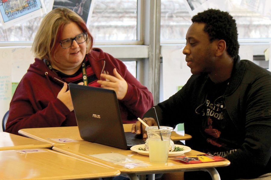 BUILDING COMMUNITY. Gesturing, middle school language teacher Deb Foote discusses with senior Robert Coats during a Spectrum meeting. Ms. Foote is the new adviser, taking over former teacher Daniel Bobo-Jones’ position. 