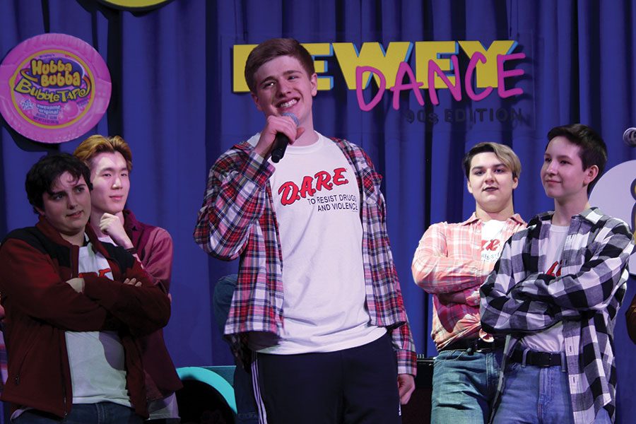 NINETIES NIGHT. Miles Warshauer belts out his solo on “The Fresh Prince of Bel Air,” as fellow Bel Canto members Luca Carroll-Maestripieri, Tommy Hsee, Nicki Sekhar and Jonah Schloerb, look on at the Dewey Dance, March 9. Bel Canto was one of several student performances at the event. 
