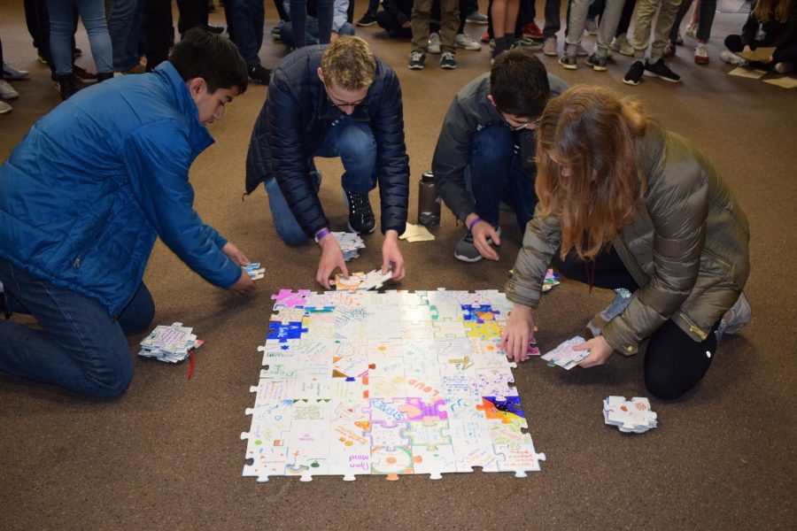 Junior Class vice president Suleyman Ahmed, Junior Class president Ben Cifu and Cultural Union representatives Kepler Boonstra and Ava Kucera disassemble a puzzle that was created by the junior class. Each individual student added a single puzzle piece describing what they brought to the grade, which was the culminating activity at junior retreat from April 9-11 at Camp Lake, Wisconsin. Juniors worked on various activities intended to foster bonds and give students a new perspective on their classmates.