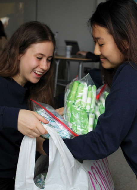 HELPING HANDS. Working side by side, juniors Annie Billings and Kathy Luan bag feminine hygiene products for homeless women. The workshop, “Break the Stigma,” taught participants about the importance of menstrual hygiene.