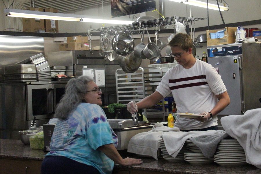 FOOD FOR ALL. Sophomore Brandon Bousquette serves food to a patron at The River Food Pantry in Wisconsin on Sept. 19. The River Food Pantry is a nonprofit that provides food, clothing and household items to Dane County families. Reflecting on the experience, Brandon said, “It allowed me to meet various new people and gain experience with people of all backgrounds.”