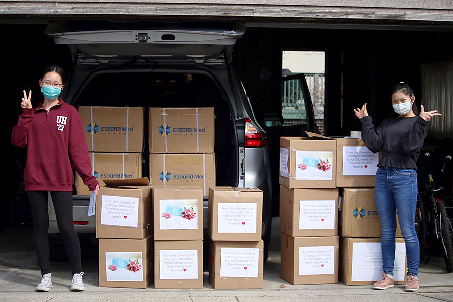 Sarina Zhao, left, and Allison Li, right, load boxes of surgical masks into their minivan for a delivery to a nursing home.