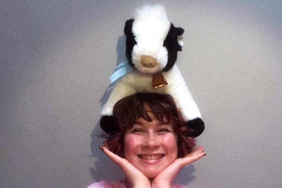 Junior Stella Heon shows off her hat that is not a hat, a stuffed cow she wore on her head in response to the friendly challenge set by Bel Canto director Katy Sinclair.