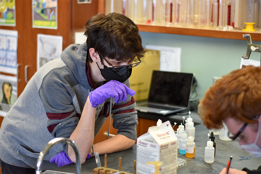Juniors Eddie Christensen and Eli Frank complete a lab for chemistry class after school. Science teachers say that laboratory experiences are too valuable to eliminate permanently as they help students prepare for real-world situations and allow for students to understand abstract concepts. 