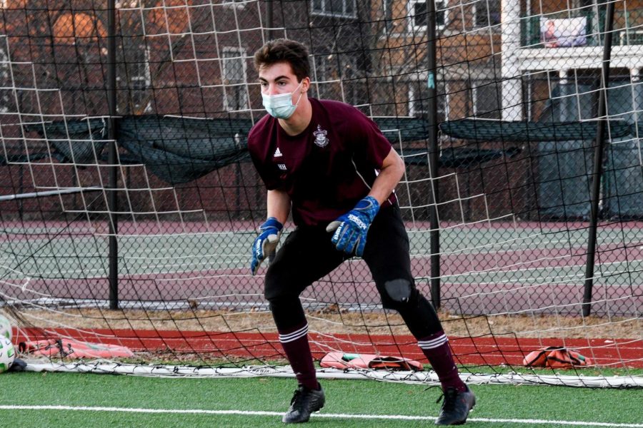 Senior Hunter Heyman keeps a goalie stance while anticipating a shot during a practice at Jackman Field March 3. Heymans leadership was a key quality in helping the boys soccer team through a challenging season.