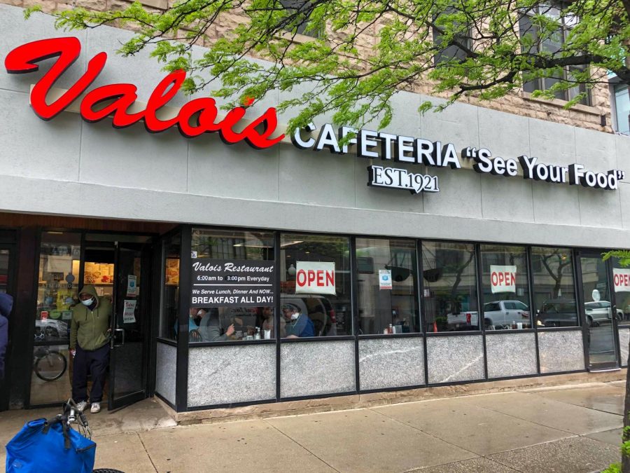 TAKEOUT.+A+customer+exits+the+Valois+storefront+on+May+19.+Many+longtime+customers+of+Valois+have+gotten+takeout+there+during+the+pandemic.+%E2%80%9CThey+actually+already+had+a+set-up+where+before+the+pandemic+you+could+get+take-out%2C%E2%80%9D+said+Seth+Richardson%2C+a+customer+for+20+years.