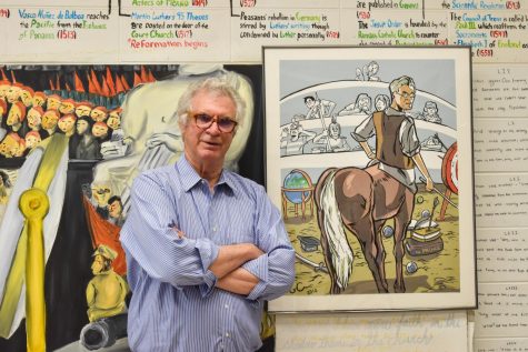 Chris Janus poses in front of murals that students painted for his AT Modern European History course in C125. “It felt good to have a physical example of the work we did in class,” Mr. Janus said. “It adds character and unique stories to each room.”
