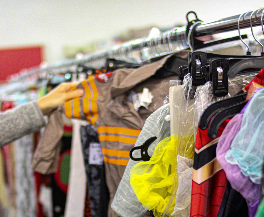 A costumer browses through a rack of Halloween costumes set out for the season at a Salvation Army. 