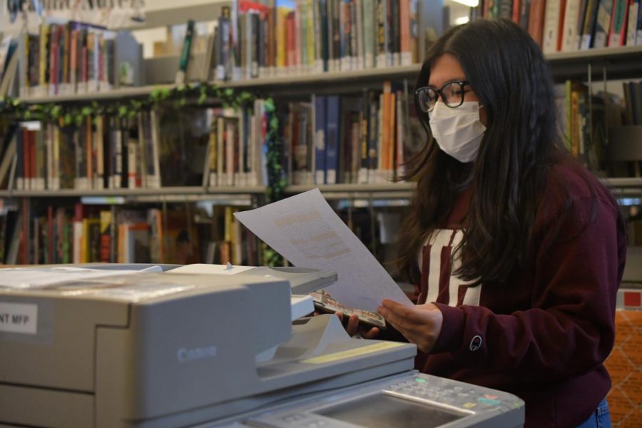 Sophomore Yolo Martinez prints an assignment in the library. Students can set up Mobility Print on their laptops to print to any of the 25 multifunctional printers throughout the school.