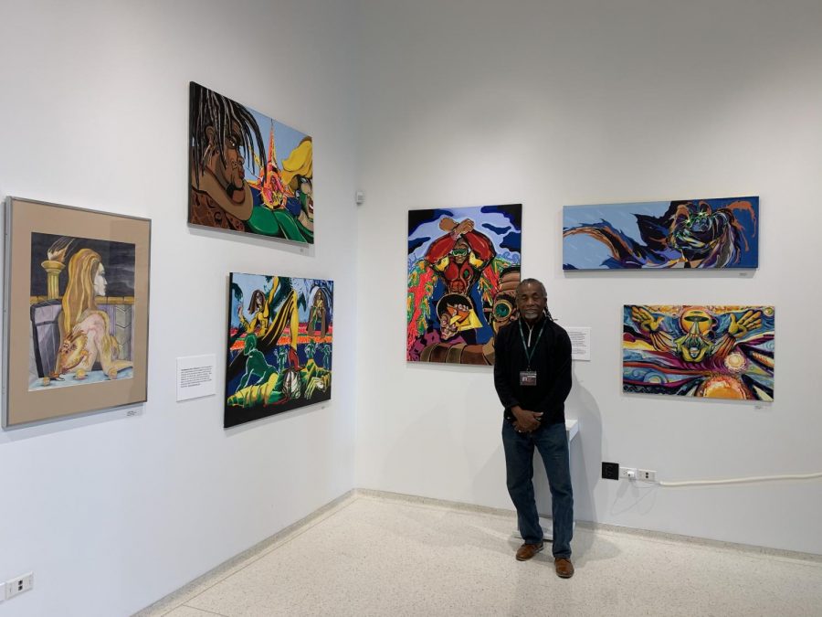 Mr. Onli stands in front of his collection in the Corvus Gallery in Gordon Parks Arts Hall.
