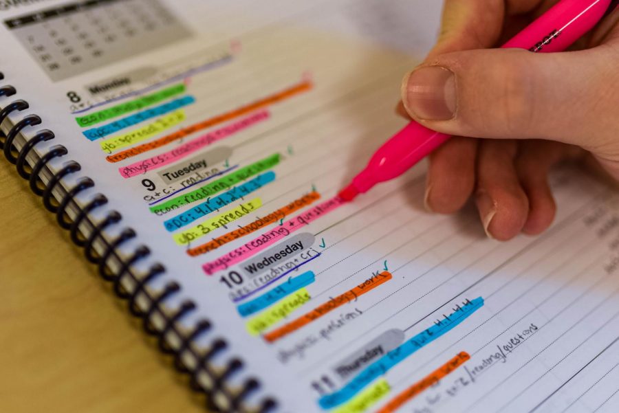 A student crosses off items from their planner. The next Program of Studies will attempt to accurately display how much work students should expect to do for each class.