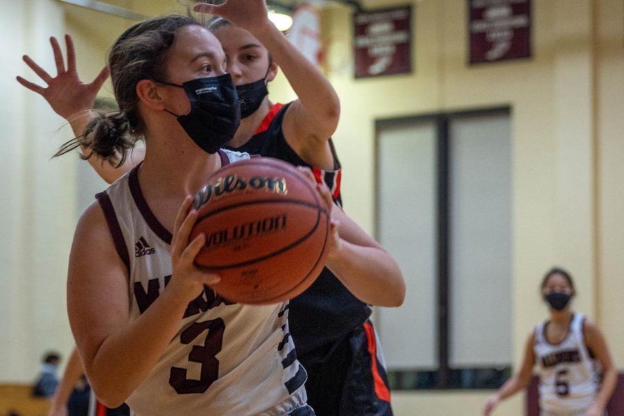 Senior Sarah Solomon looks for an open teammate to pass to in a basketball game on Feb. 1.