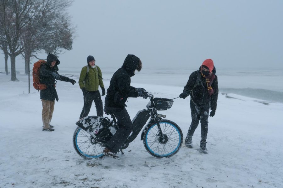 Senior Julien Derroitte attempts to ride a Divvy bike near Promontory Point during the snow day Feb. 3.