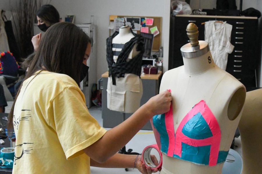 Junior Maya Herron adds duct tape to her project in the fashion design workshop.