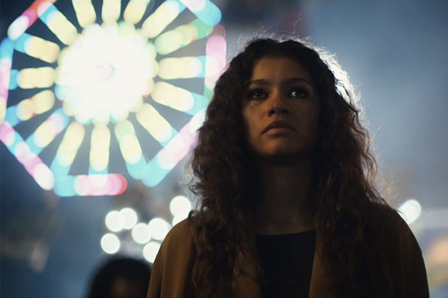Main character Rue Bennett on HBO Maxs Euphoria stands in front of a carnival in Season 1. 