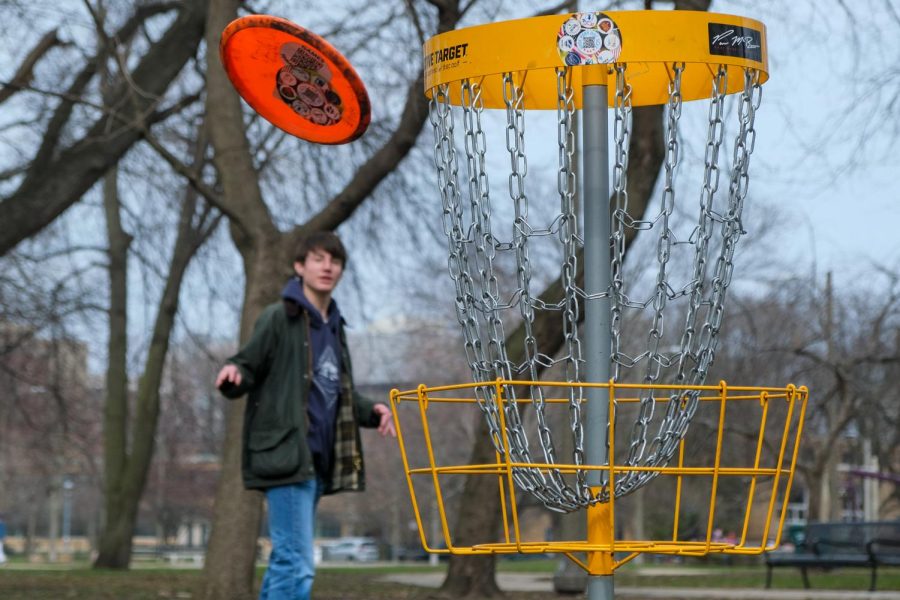 HOLE-IN-ONE. Senior Spencer McKula throws a frisbee toward a putting basket at Nichols Park on April 5. For a full disc golf course, players can go to the Illinois Institute of Technology at 33rd and State streets. In Hyde Park, putting baskets are located in Nichols Park
and near Promontory Point.