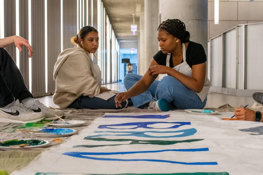 BRAVE BRUSHES. Sophomores Leila Battiste and Ella Cohen-Richie paint the BRAVE logo during the BRAVE mural painting workshop. Mural painting was offered for the first time this year.