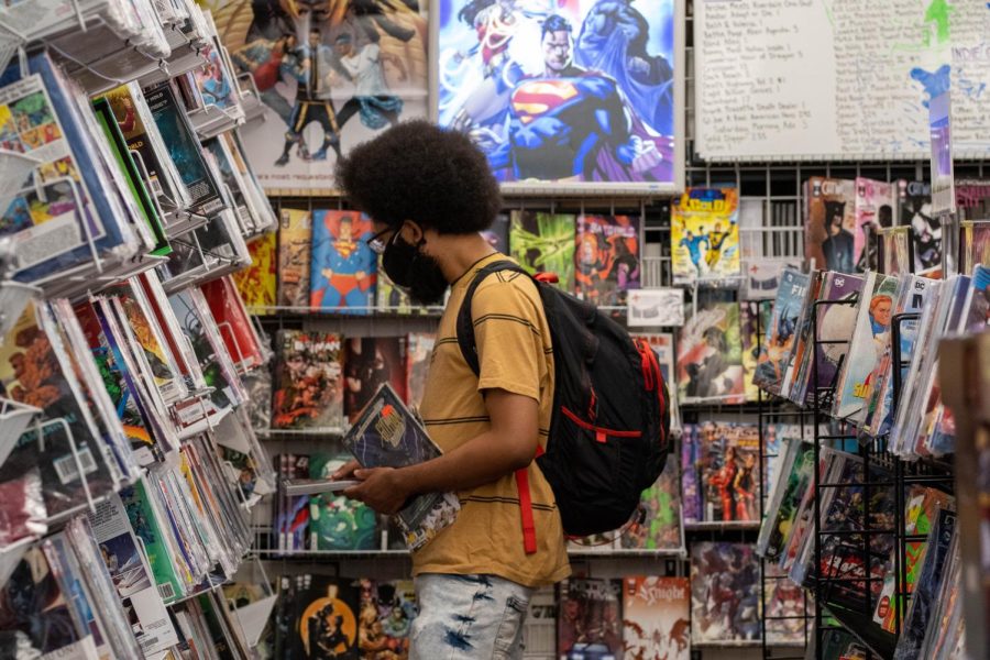 A customer browses through First Aids comics collection, book in hand.