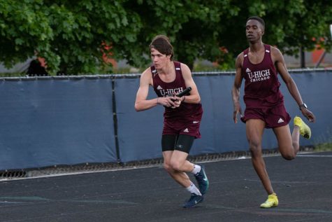 Junior Luke Grotthus takes the baton from junior teammate William Montague. The two were part of a 4x400 meter relay including juniors Cristian Ferreyra and Sohan Manek. 