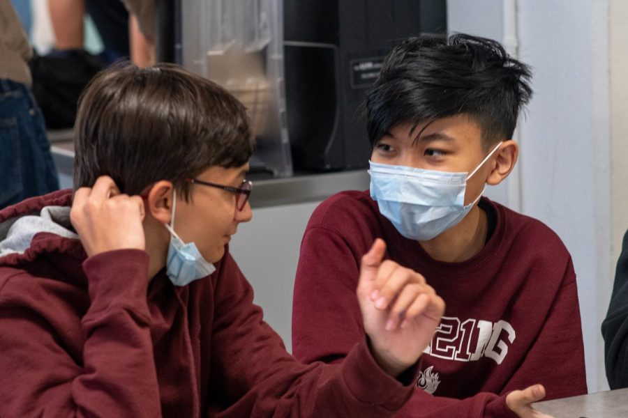 Ninth graders Rohan Gengler and Joonsung Kim converse. The University of Chicago is recommending individuals on its campus to wear a mask indoors.