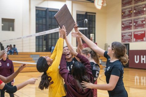 The volleyball team celebrates their victory in their ISL regional finals match against King High School.