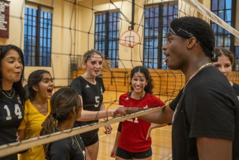Seniors Kenneth Peters and Charlotte Henderson shake hands across the volleyball net. The soccer and volleyball teams faced off in a match on Nov. 16 to raise money for the Greater Chicago Food Pantry.