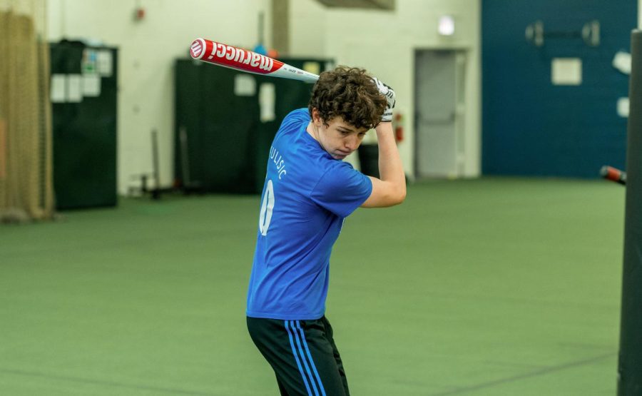 EXPERIMENTAL SEASON. Sasha Duda prepares to swing during practice with his team at the Henry Crown Field House. Sasha and his teammates are participating in a University of Chicago economics study.