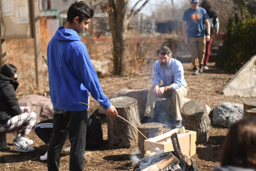 Sophomore Anik Shetty roasts a marshmallow over a campfire in the Outdoor Classroom. In “Smores in the Outdoors,” students enjoyed time outside and making s’mores. 