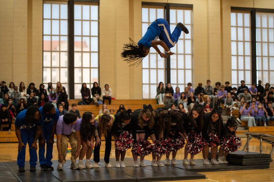 A member of the Chicago Boyz Acrobatic Team flips over students participating during the Closing Ceremony on March 1. The acrobatic team is composed of professional young male gymnasts in the Chicago Area. 