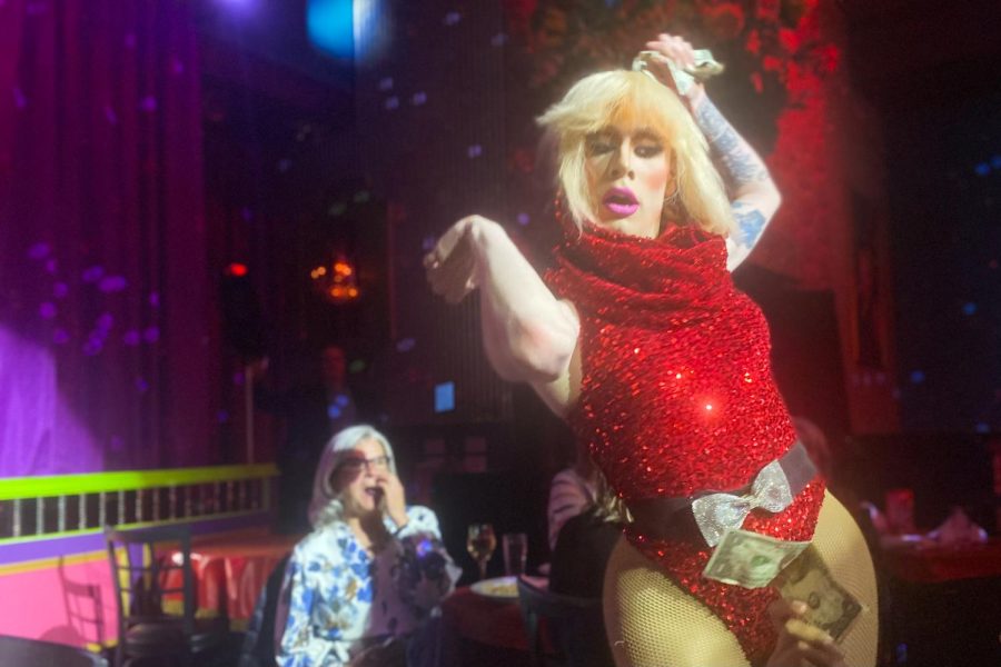 At Lips Chicago on May 19, during a drag show and dinner, drag performer Priscilla Rock dances amid flashing, colorful lights as viewers offer cash.