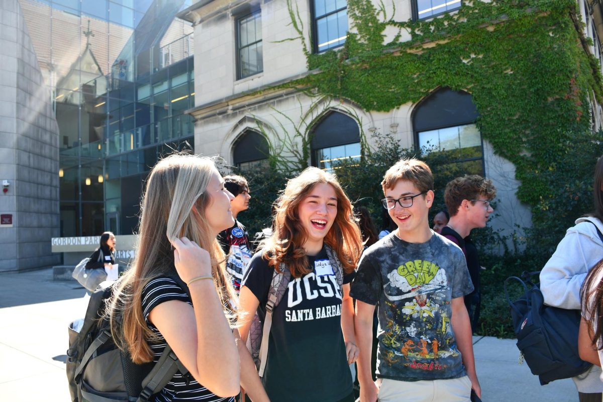 ORIENTATION SMILES. Tyra DeWeese, Ledya Wreden and Justin Salomon laugh as they walk to the buses to depart on ninth grade retreat, on Aug. 31. The Class of 2027 met their advisers after completing a scavenger hunt.