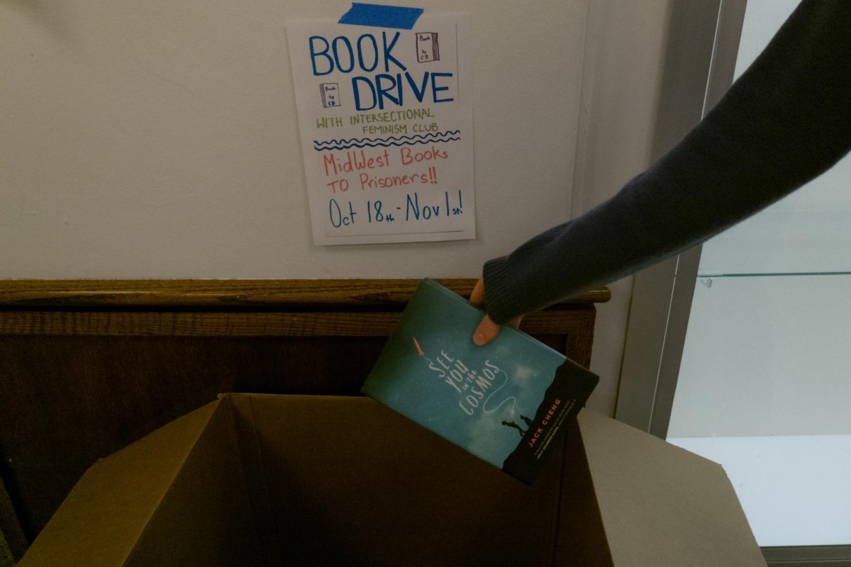 A student drops a book in the book collection drive for incarcerated people, sponsored by the Intersectional Feminism Club. Donations will be accepted through Nov. 1 in the high school lobby.