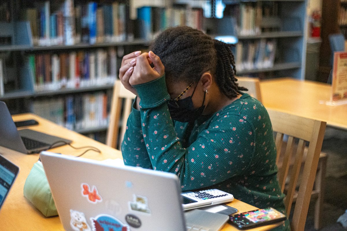 A student clasps their hands in the library, overwhelmed by stress. While stress is unavoidable, its essential for students to recognize the intensity of the effects and causes of stress in order to manage it.