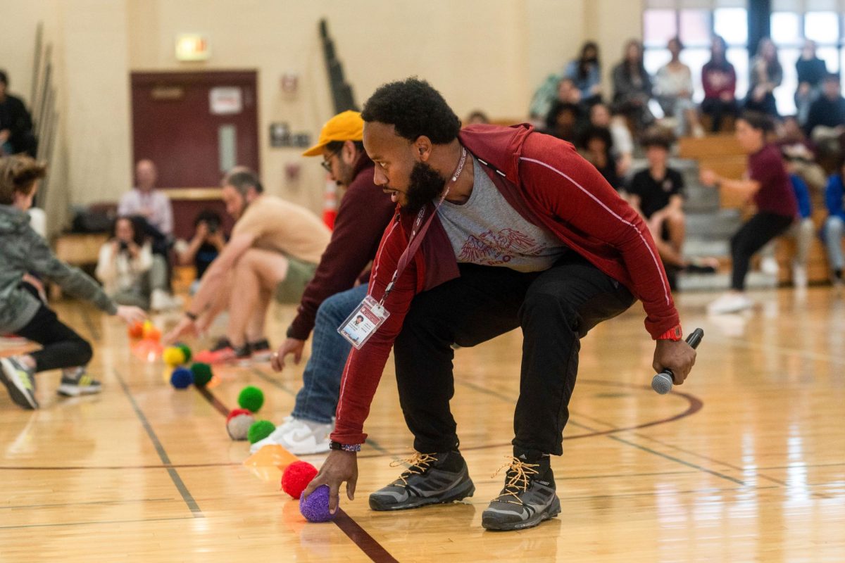 Counselor Teddy Stripling, organizer of the student-faculty games, leans over to pick up a ball at the beginning of the yarn ball dodgeball game. Along with fine arts teacher Aaron Arreguin, Mr. Stripling was one of the last two adults in the game before the students eliminated all, winning the game after two and a half minutes of chaos and action.
