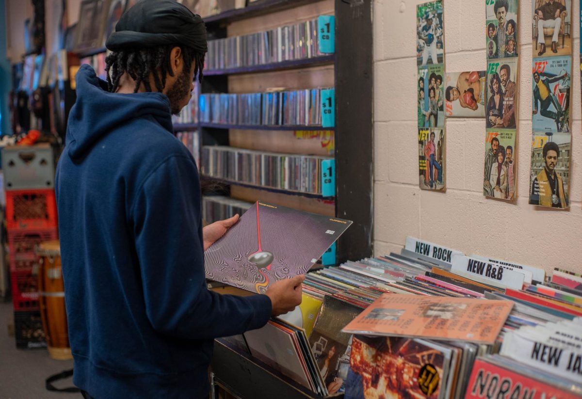 Holding a Tame Impala record, a customer browses through records at Hyde Park Records on 53rd street. Vinyl has seen a recent boom in popularity, despite the other listening platforms available.