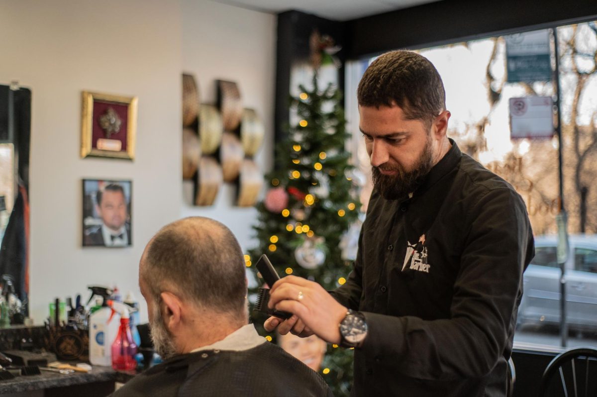 Barber and immigrant Illyria Grezda enjoys salon atmosphere