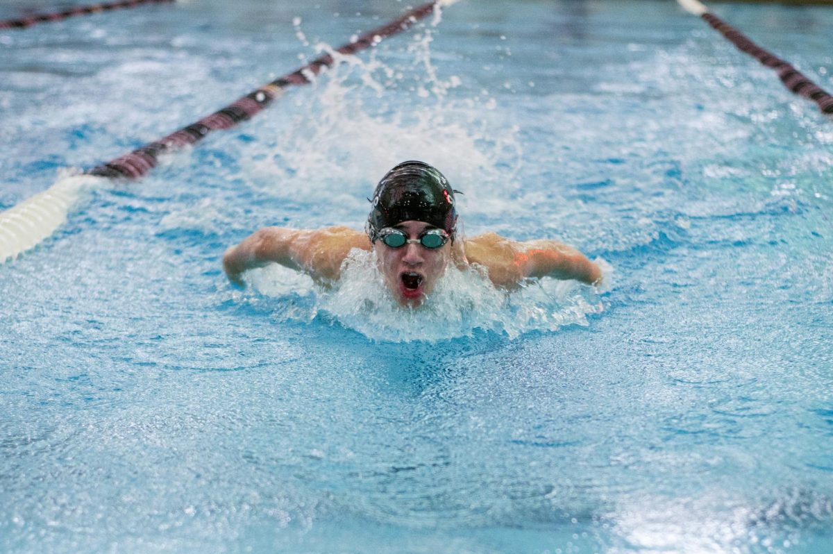 Gliding through the water, sophomore Julian Rossi uses the butterfly stroke to propel himself along the length of the swimming pool at Ratner Athletics Center on Feb. 3. The boys swimming team ended the season at the IHSA sectional finals, coming in fourth place overall. 
