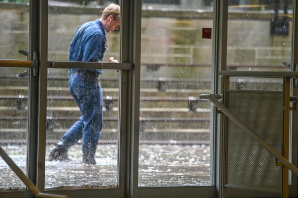 A worker with the University of Chicago Facilities Management department walks through rainwater pooled outside of the cafeteria on the afternoon of May 7. The rain accumulated about three inches in the sunken area below Blaine Courtyard. Students got soaked trekking through the treacherous conditions to and from the gymnasium building.