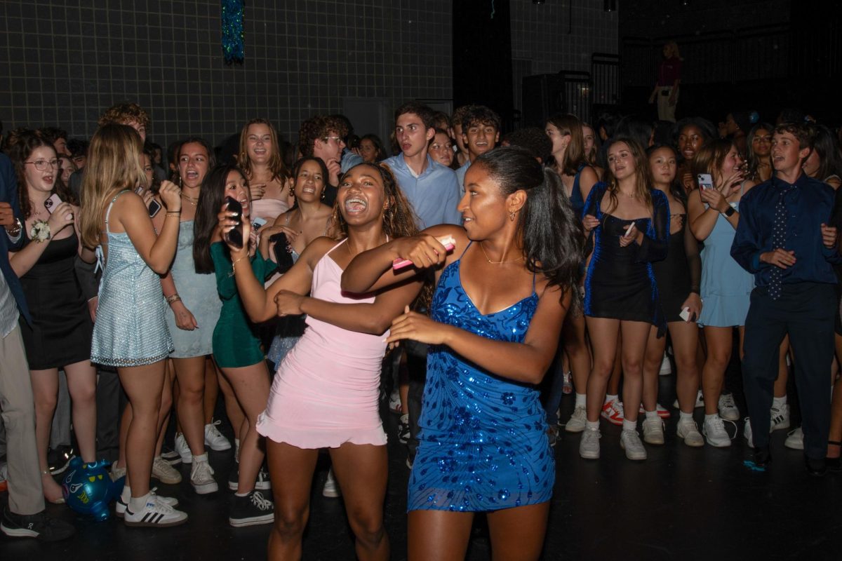 Dancing to “Wobble” by VIC, junior Xia Nesbitt and sophomore Savannah Woodson sing along at the homecoming dance, themed “A Night Under the Sea,” on Sept. 21. 534 students attended.