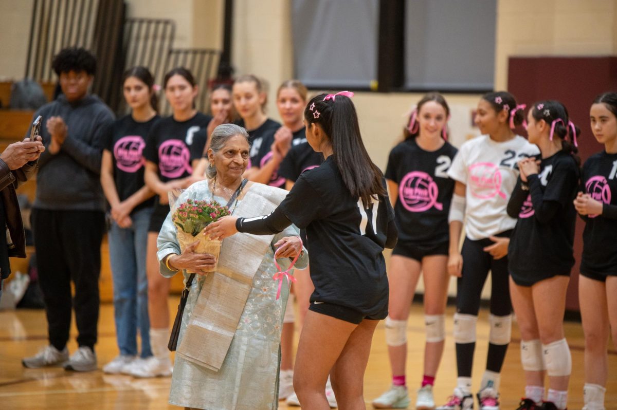 Senior Kaavya Peddinti hands her grandmother, Viyaja Vedantam, a bouquet at the Dig Pink volleyball game on Oct. 25 in Upper Kovler Gymnasium. The U-High varsity team ended up losing 0-2 but raised around $2,300.
