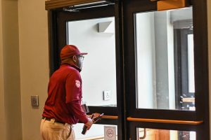 Community Service Officer Sam Ntone heads out the doors of the U-High lobby to patrol the school grounds. The security team is increasing the number of surveillance rounds made by officers this year.