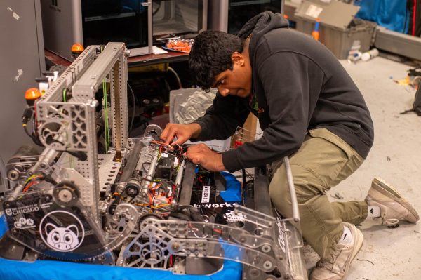 Robotics team coordinator Ketan Kandula works on a robot before a demonstration. The U-High robotics team placed third in the Boiler Bot Battle at Purdue University.