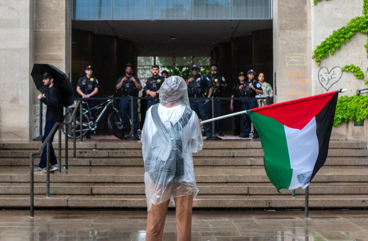 May 3, 2024 — Showing a demonstrator for the UChicago United for Palestine encampment on the Main Quad, waving a Palestinian flag in front of a group of police, this powerful photo captures the heart of the encampment. 