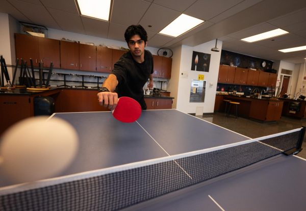 Senior Zarak Siddiqi plays pingpong in physics teacher Francisco Saez's room. The game has become a fun, engaging tradition.