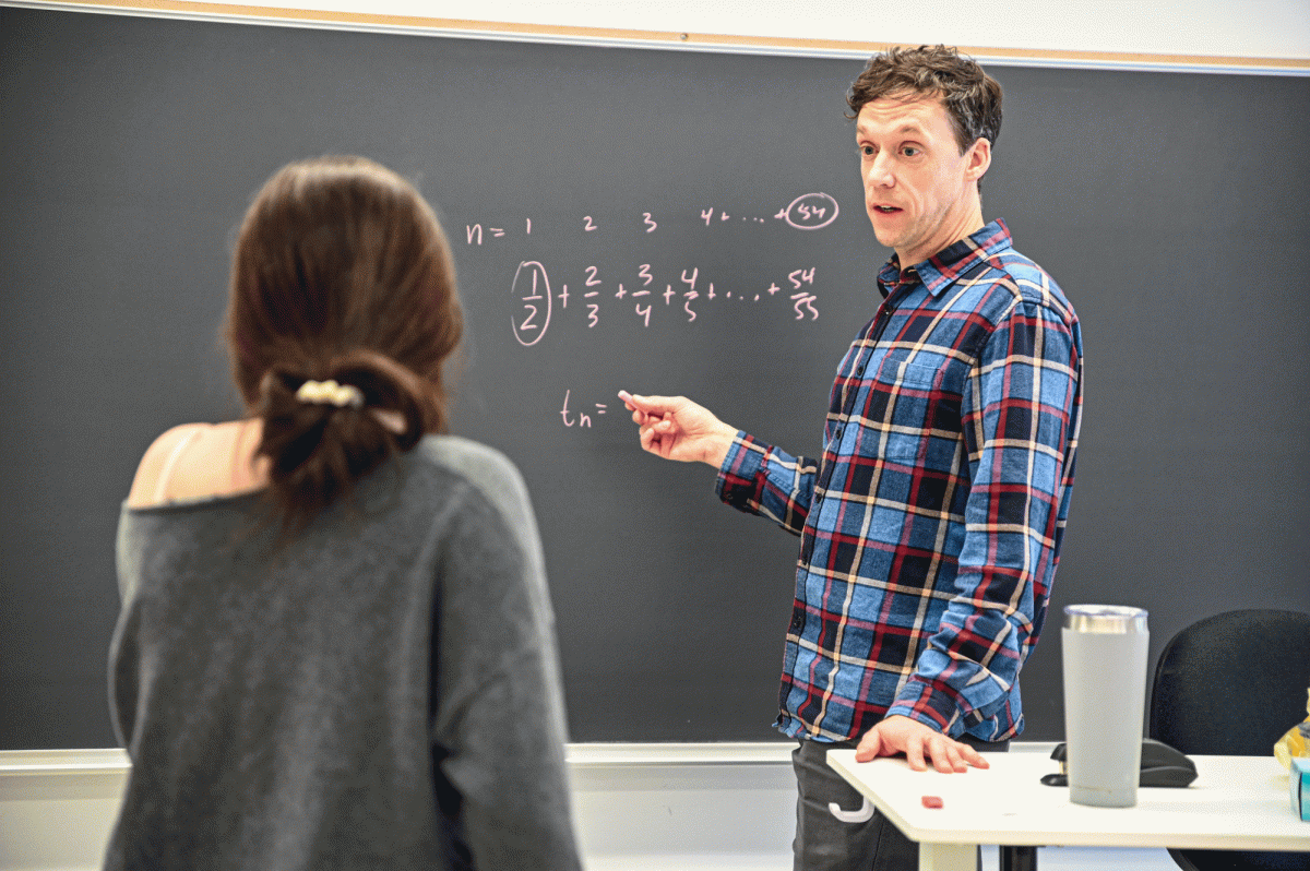 Math teacher Ross Hunefeld helps sophomore Freddie Neater-DuBow through a math problem. Some students have felt pressure on how they should be using their free time.