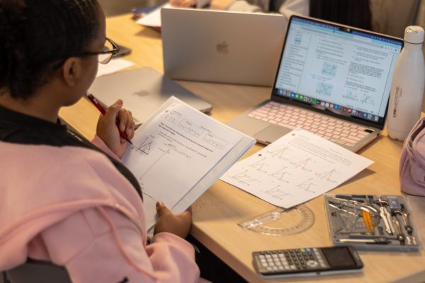 Ninth graders complete math homework in class. At Lab, some female students feel isolated in STEM courses, specifically in advanced math classes.